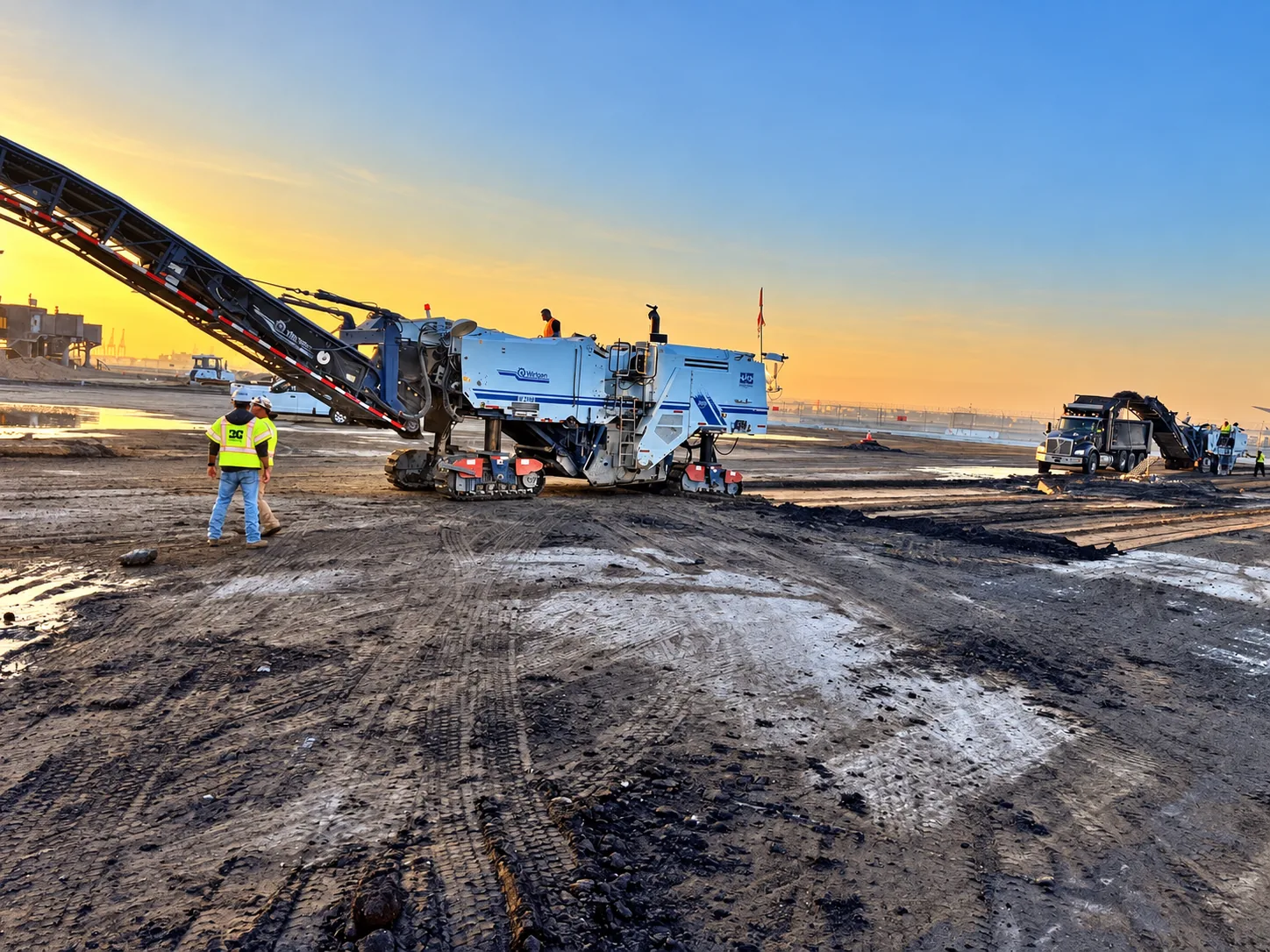 Construction equipment working at sunrise on an active jobsite.
